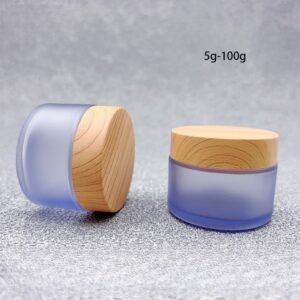 Frosted matte finish cylindrical glass cream jar with black lid, empty skincare container